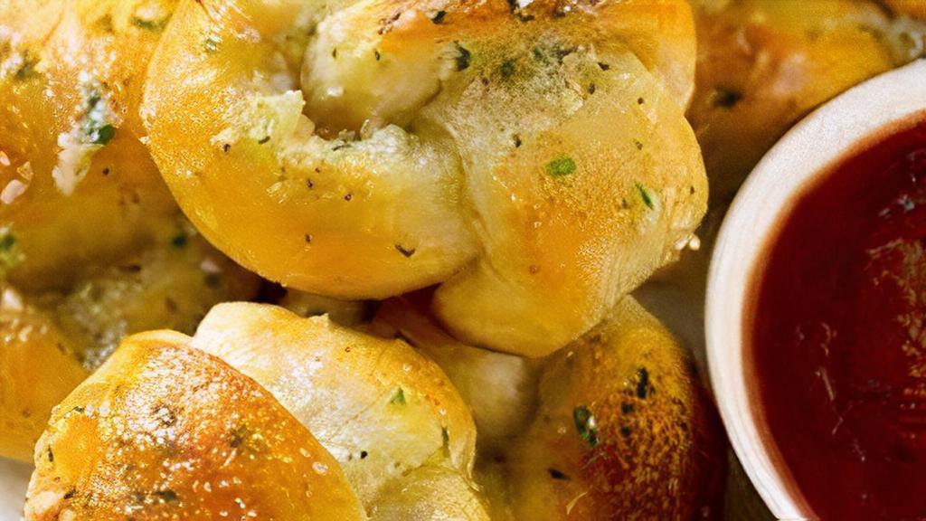 Garlic Knots. · Our house made pizza dough, knotted up, baked, then smothered in real garlic butter and parmesan cheese.