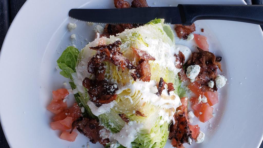 Wedge Salad · Classic wedge, 1/4 head of iceberg, blue cheese crumbles, diced tomatoes, bacon, blue cheese dressing