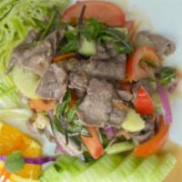 Beef Salad · Grilled thinly slice beef mixed in lime juice, cilantro, red onion, carrot, mint, lettuce, t...
