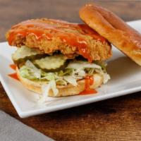 The Hot Chick Sandwich · Crispy fried chicken breast, spicy wing sauce, lettuce, and dill pickles on butter grilled r...