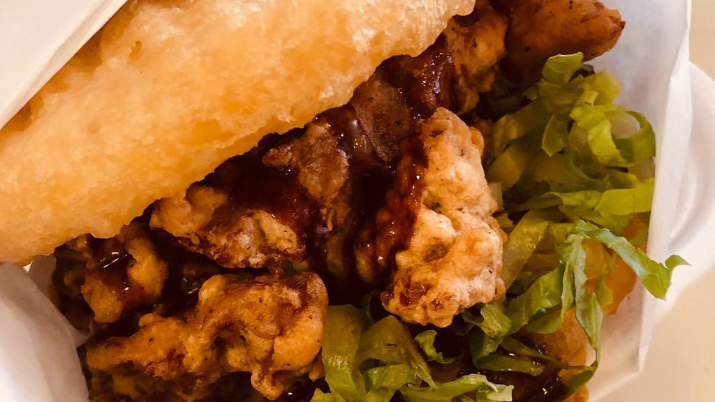 Chicken Karaage Sushi Burger · Japanese style deep fried chicken with lettuce, savory chef signature sauce squished between two golden rice buns.