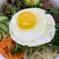 Bibimbap · A traditional Korean mixed rice bowl with cucumbers, green and yellow zucchini, carrots, spi...