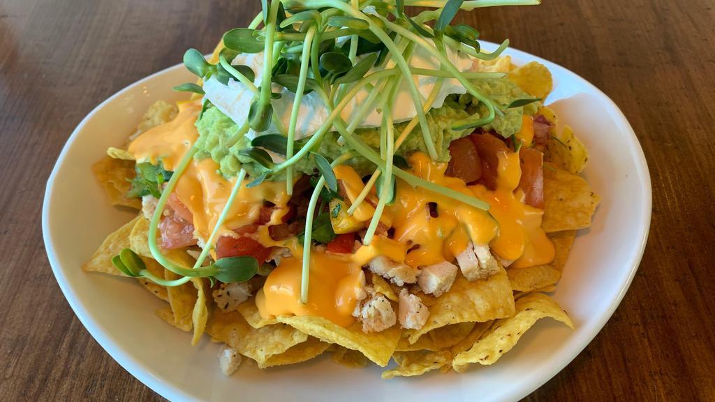 Nacho With Chicken And Microgreens · Nachos with corn tortilla chips, our store-made salsa, melted cheese, sour cream, guacamole, grilled chicken, and topped with our store grown sunflower microgreens.