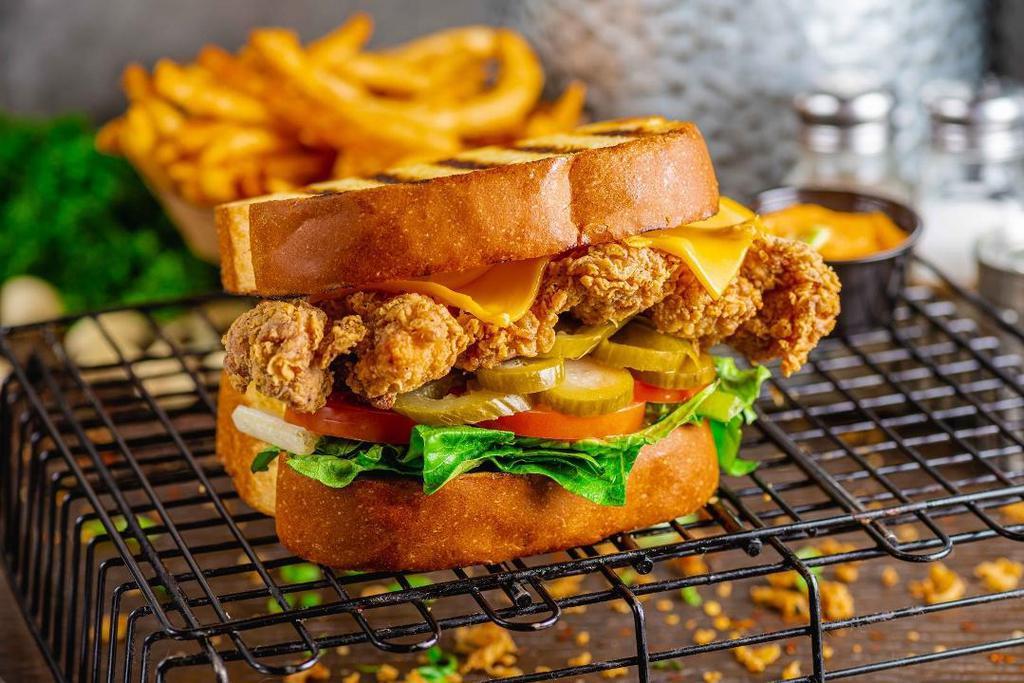 Clucks N' Toast - Sandwich · Crispy, hand-breaded, whole chicken thigh between grilled, thick cut, Texas toast. Served with shredded lettuce, tomato, pickle, choice of cheese, sauce, and served with fries. Try our OMG Cluck Sauce!