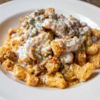 Irish Nachos · Back by popular demand. A basket of tots, layered with our house-made white queso, and green...