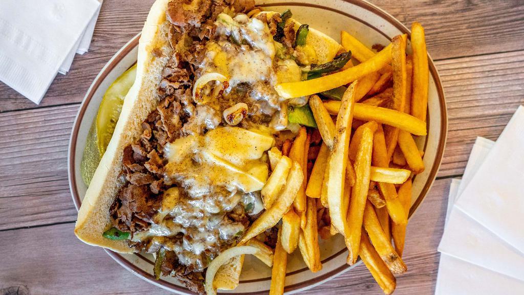 Philly Cheese Steak Sandwich · Served with sautéed onions, peppers & mushrooms, Swiss cheese & fries.