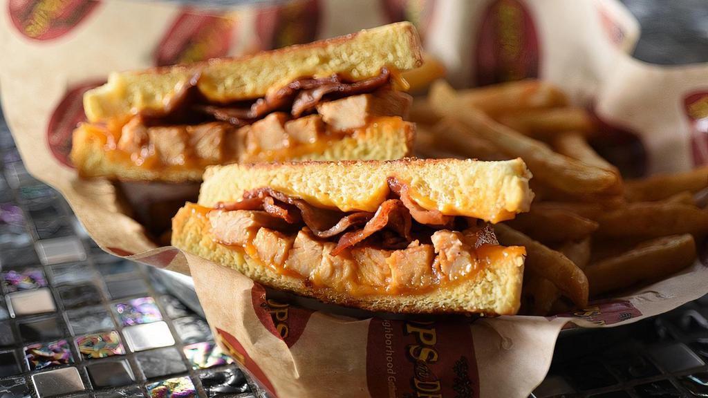Spicy Grilled Cheese · Spice up your life with this one! Chicken smothered in cheddar & American cheeses, HopsnDrops wing sauce and bacon. This has just the right amount of kick to it!