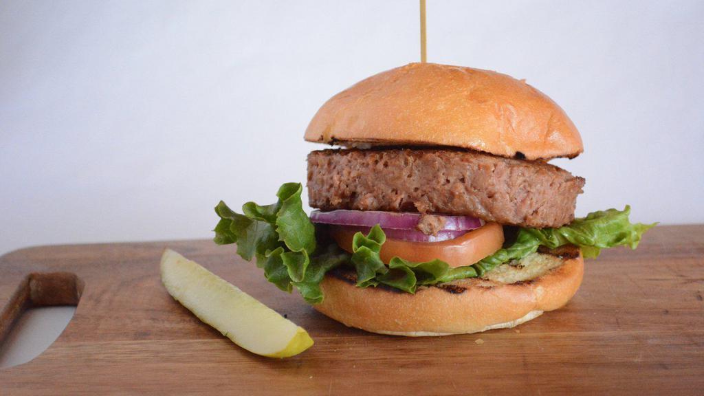Veggie Classic Burger · Beyond burger patty topped with tomato, red onion, lettuce, and pickles on a brioche bun.