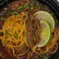 Birria Ramen · Slow-cooked beef broth with ramen noodles topped with cilantro and onions.