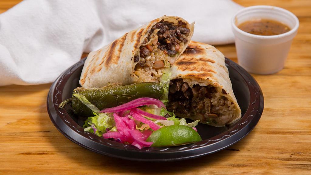 Carne Asada Burrito · Includes: rice, pinto beans, pico de gallo, and salsa.