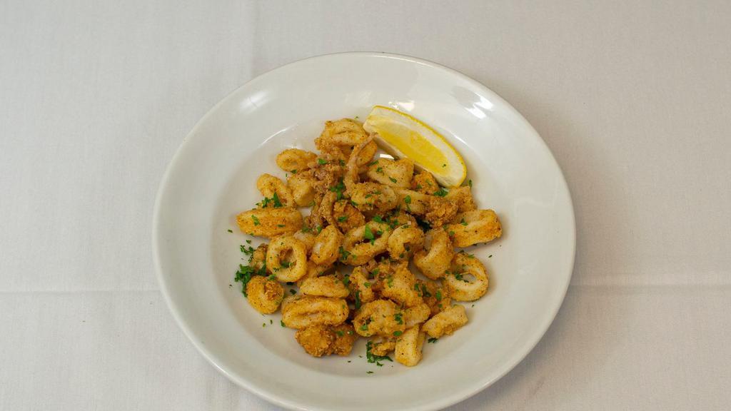 Calamari · Crispy fried squid tossed with sea salt and fresh parsley, house tartar sauce and lemon.