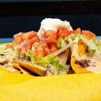 Trash Nachos With Queso · Pieces of deep-fried corn tortilla chips with chopped gourmet burger patty smothered in our ...