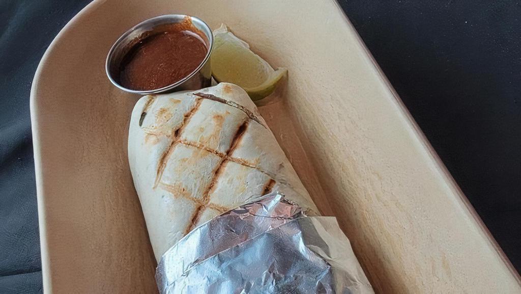 Carnitas Burrito · Traditional citrus, guajillo & garlic-braised pork, pickled red onions, pico de gallo, sour cream, and Monterrey jack cheese in a grilled flour tortilla with a side of spicy 3-chile sauce.