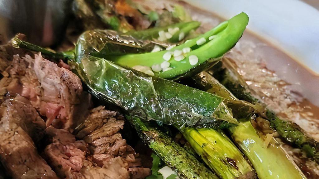 Carne Asada · Marinated & grilled steak with cantina beans (contains pork), red rice, roasted chilies, grilled mixed vegetable, and green onions. Served with LWC salsa macha and tortillas.