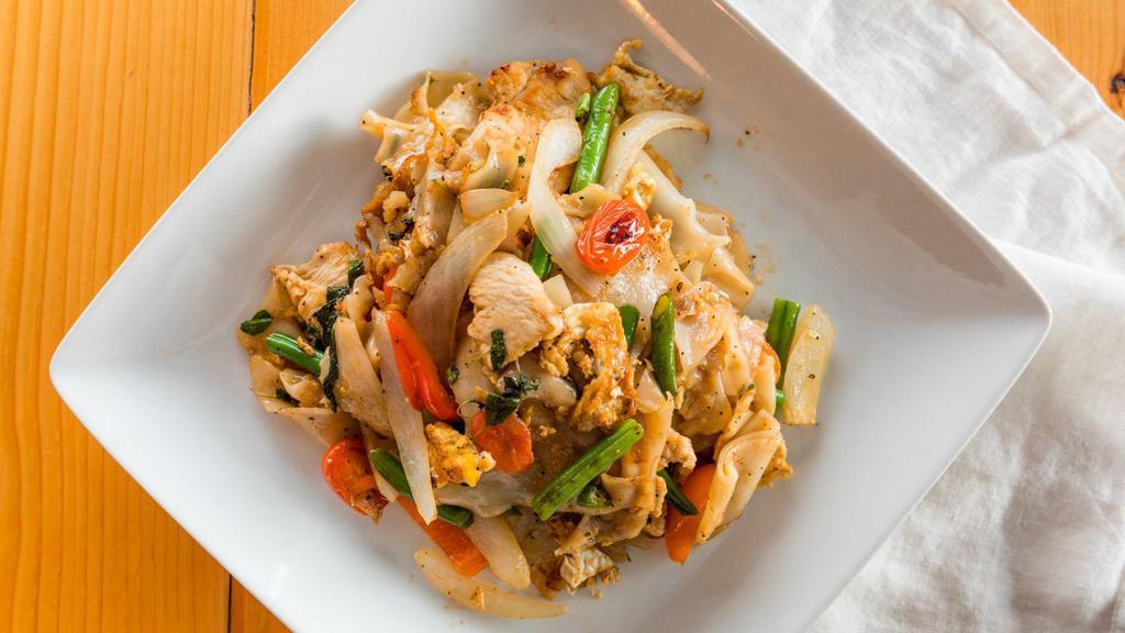 Pad Kee Mao · Stir-fried wide rice noodles with egg, green bean, onion, tomato, sweet pepper, and holy basil in garlic sauce.