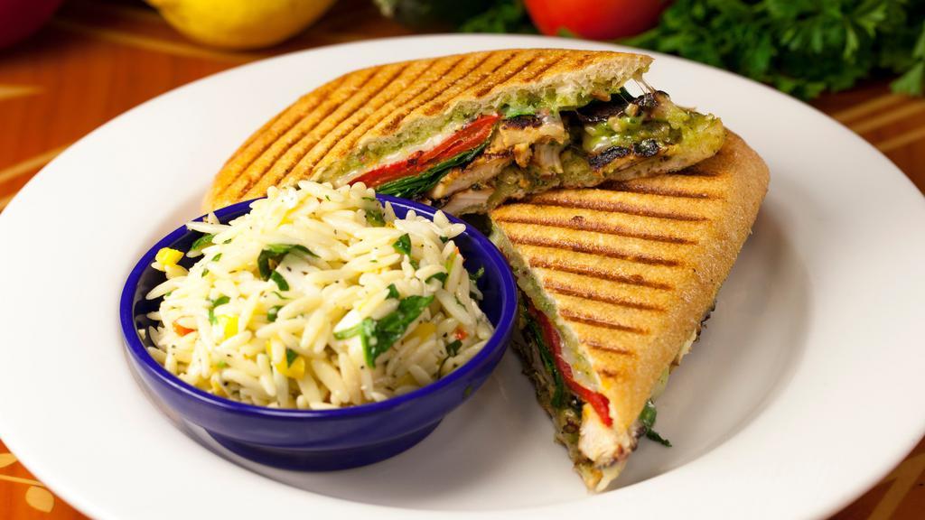 Grilled Chicken-Pesto Panini · Tender grilled chicken breast with provolone cheese, fresh spinach, and roasted red pepper. The panini is toasted and smeared with a roasted garlic-pesto mayonnaise.