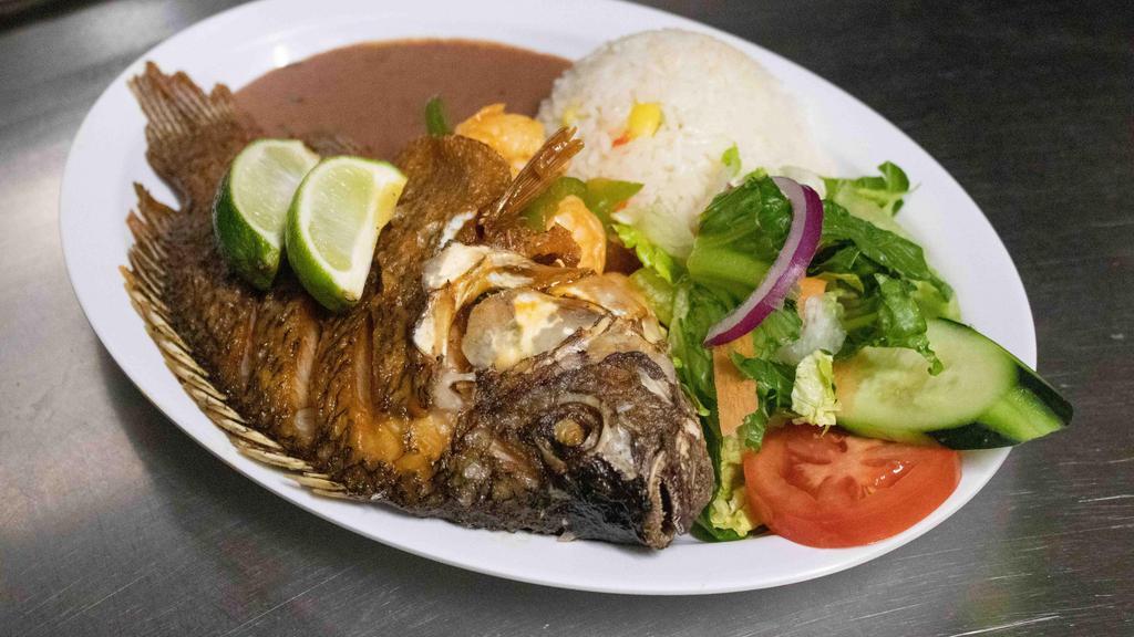Mojarra Rellena De Camaron · Fried tilapia filled with shrimp, served with rice, beans and salad.