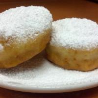 Beignets · Two French-style southern doughnuts covered with powdered sugar