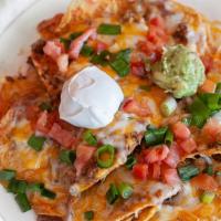 Super Nachos · Chips, cheddar cheese, beans, sour cream, guacamole, onion and tomatoes.
