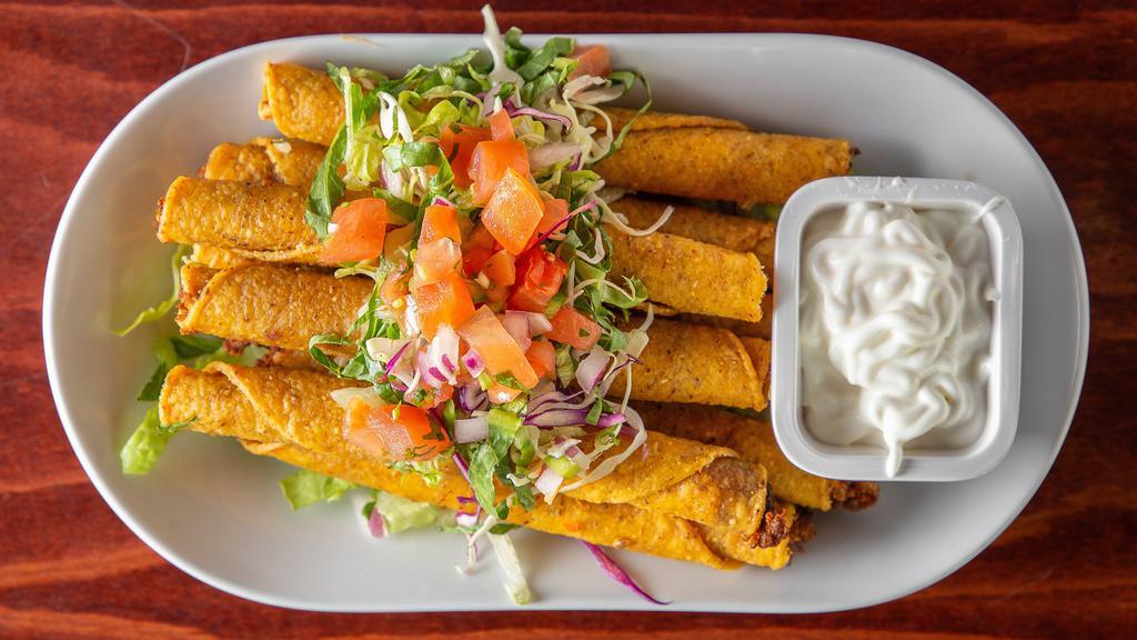 Chicken Taquitos · Eight rolled and fried taquitos with chicken, served with shredded mix lettuce, garnished with diced tomatoes on top and sides of sour cream and green salsa.
