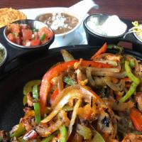 Fajitas · Your choice of marinated chicken or steak, seared with peppers and onions, with a side of Sp...