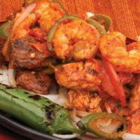 Fajitas Mariachi · Shrimp, beef, and chicken fajitas sautéed with onions, tomatoes, and bell peppers.