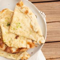Garlic Naan · Flat leavened bread garnished with garlic and cilantro baked in the tandoor oven, topped wit...