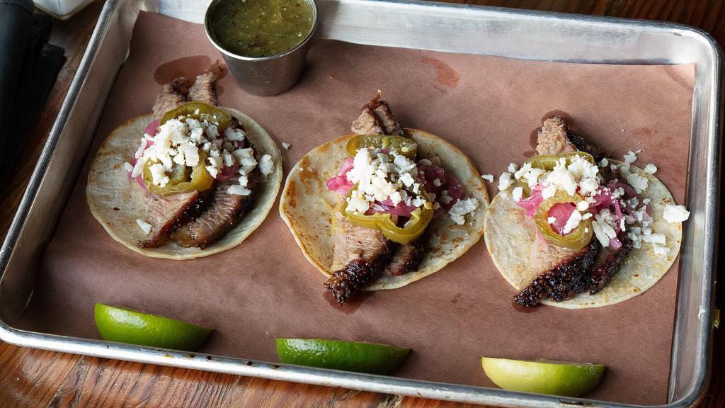 Three Brisket Tacos · Choice of salsa verde or salsa roja, pickled jalapeño, red onion, queso fresco,. lime wedges, house-made fresh corn tortillas (G) (S)
