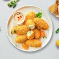 Cheesy Poppers · (Vegetarian) Fresh jalapenos coated in cream cheese and fried until golden brown.