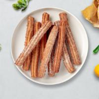 Champ'S Churros  · This sensation is well worth all the hype. Cinnamon sugar-dusted churro disks served with yo...