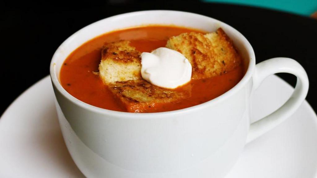 Tomato Basil Soup · Our signature creamy tomato basil soup drizzled w/sour cream & topped w/our famous grilled cheese croutons. Served daily.