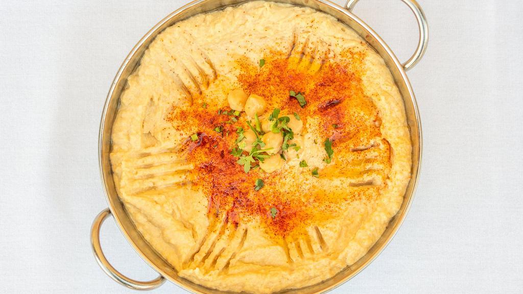Hummus · A blend of chickpeas puree with garlic lemon juice and tahini. Served with a drizzle of olive oil.