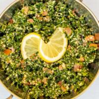 Tabbouleh · Thinly diced parsley tomatoes onions and mint mixed with bulgur lemon juice and olive oil.