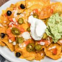 Nachos · Corn chips smothered in pork sauce and beans, topped with melted cheese and garnished with t...