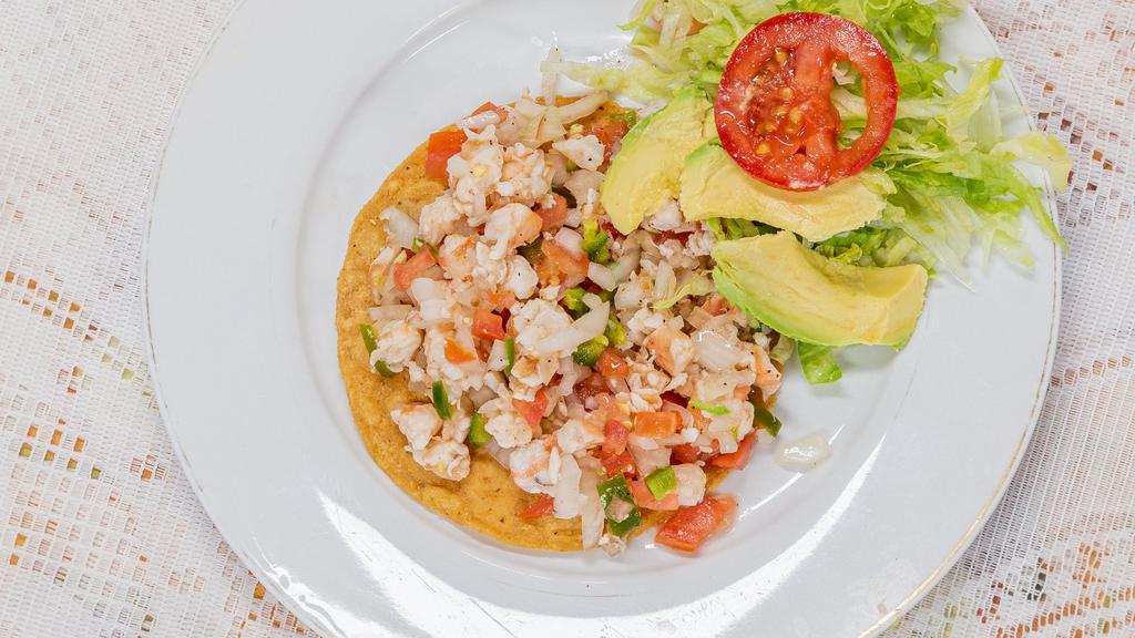 Tostada De Ceviche · A shrimp ceviche tostada.

These items may be served raw or undercooked or may include raw or undercooked ingredients. Consuming raw or undercooked meats, seafood, shellfish or eggs may increase the risk of foodborne illness.