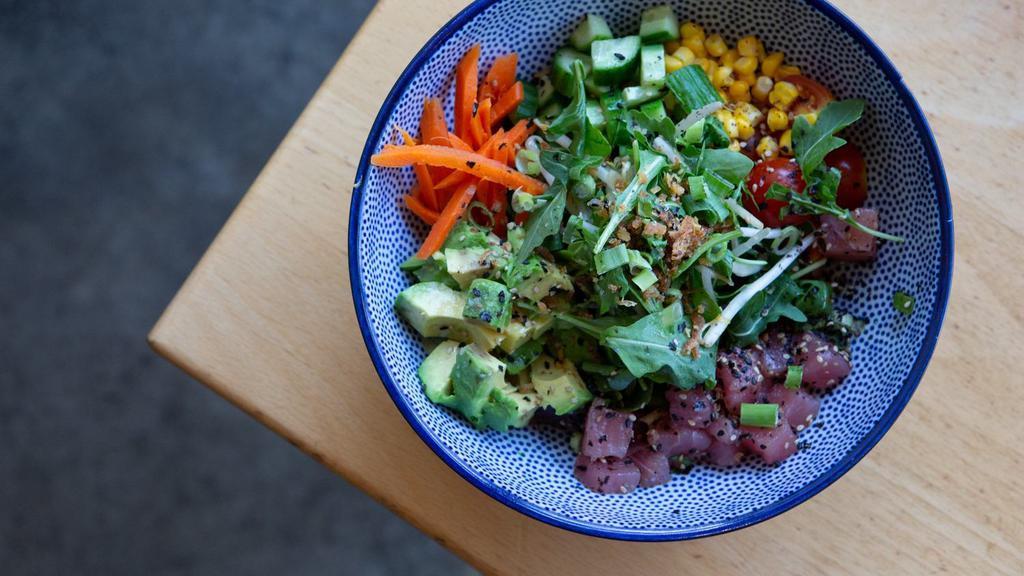 Poke Bowl · Wild yellowfin ahi tuna poke. Served over chilled ramen noodles or green onion ginger rice. With lemon soy vinaigrette, Persian cukes, avocado, and seasonal veggies. Contains soy sauce.