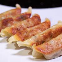 Gyoza · Pan-fried dumplings stuffed with pork and vegetables and gyoza sauce.