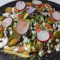 Califries Asada · French Fries topped with beans, Grilled ASADA, cheddar cheese, onion, cilantro, tomato, sour...