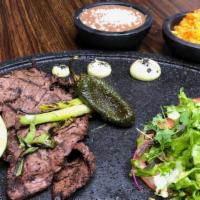 Carne Asada · Grilled Arrachera steak  rice, beans,  avocado, grilled onion,  fried jalapeño, salad and  c...