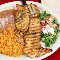 Pollo Asado · marinated grilled chicken, refried beans, rice, salad, guacamole, and corn/ flour tortillas.