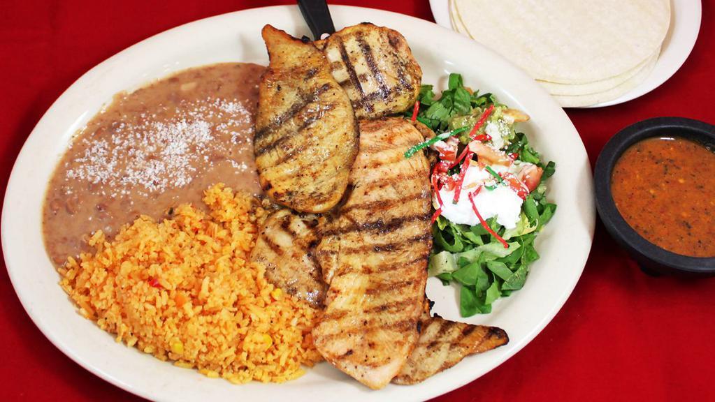 Pollo Asado · marinated grilled chicken, refried beans, rice, salad, guacamole, and corn/ flour tortillas.