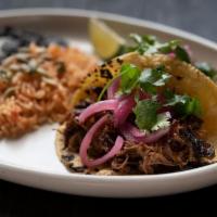 Smoked Brisket Tacos · Two tacos with housemade corn tortillas—hand-pressed daily. Served with Spanish rice and cum...