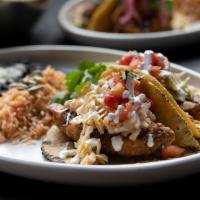 Baja Fish Tacos · Two tacos with housemade corn tortillas—hand-pressed daily. Served with Spanish rice and cum...