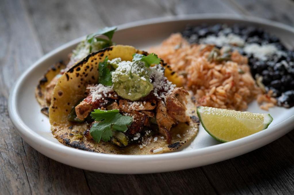 Ancho Chicken Tacos · Two tacos with housemade corn tortillas—hand-pressed daily. Served with Spanish rice and cumin black beans. We’d be happy to substitute lettuce cups for tortillas on request.. Ancho chile marinated chicken breast, charred tomato salsa, jack cheese, guacamole, cotija cheese, cilantro. . We charge 20% more for items on ALL third party delivery sites to cover the commission they charge us.  If you want to avoid this premium, we invite you to order for delivery or take-out . at www.CactusRestaurants.com.
