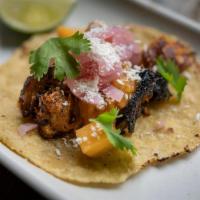 1 Taco Carnitas · Achiote pork braised in banana leaves, caramelized pineapple salsa, red onion escabeche, cot...