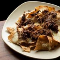 Kids Brisket Nachos · Housemade chips and melty cheese with smoked brisket. That’s it.