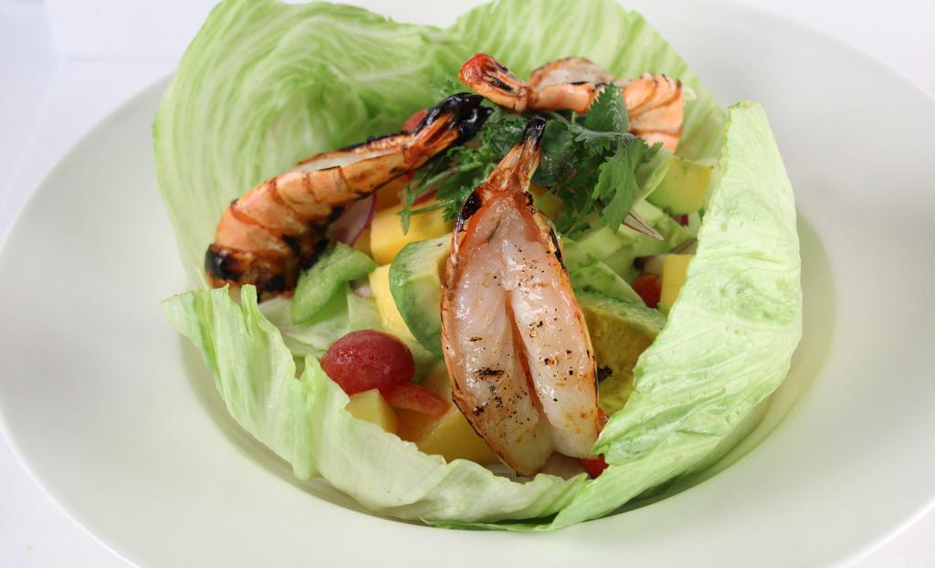 Mango Avocado Salad · Freshly sliced mango and avocado lightly tossed in light sweet and sour dressing, along with cilantro, red onion, bell pepper and tomato. Served with three whole prawns straight off the grill. 
Gluten free.
Recommended.