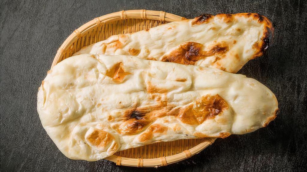 Naan · A traditional unleavened, hand-tossed bread freshly baked in a tandoor clay oven.
