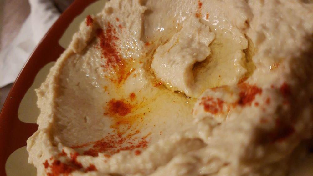 Hummus · Served with naan. A thick paste made from ground garbanzo beans, tahini sauce, olive oil, lemon, and garlic.