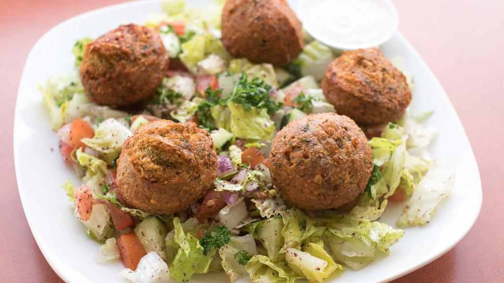 Falafel Salad · Deep fried chickpea patties served over a mixed salad. romaine, tomato, cucumber, onion, garlic paste, sumac, and house vinaigrette. Served with tahini sauce.